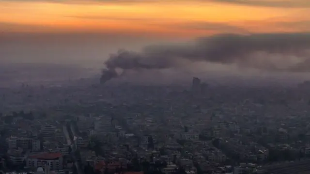 An aerial image shows smoke billowing after airstrikes in Damascus on Tuesday morning