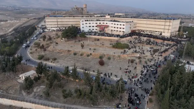 This aerial photo shows people gathering at the Saydnaya prison in Damascus on December 9, 2024.