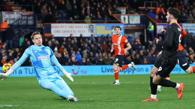 Stoke striker Tom Cannon guides a finish past Luton goalkeeper Thomas Kaminski