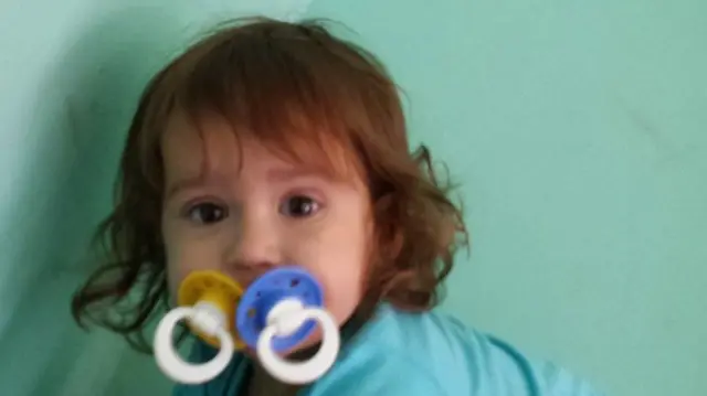 A picture of a baby's head with two dummy's in