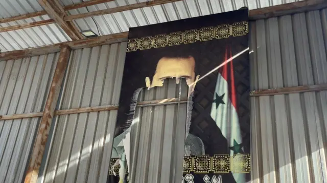 Political poster of Bashar al-Assad torn up