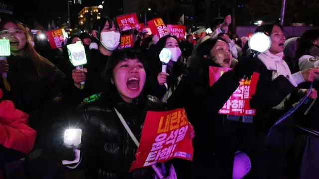 Protesters hold candlelights and placards calling for the impeachment of South Korean President Yoon Suk Yeol during a demonstration in Seoul