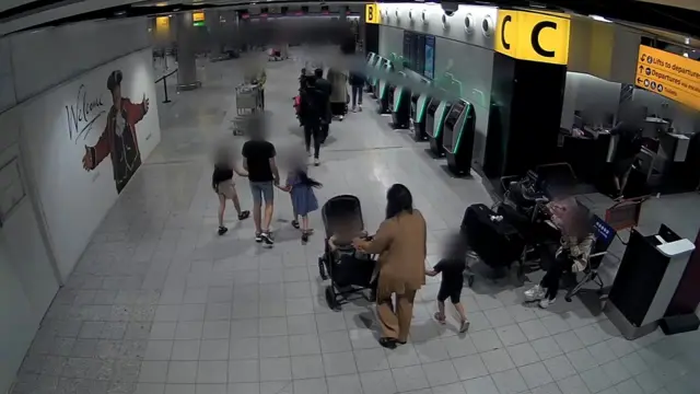 CCTV shows a woman pushing a pram and walking next to a child, and a man holding the hands of two children