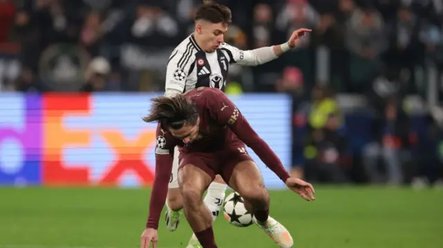 Francisco Conceicao of Juventus challenges Jack Grealish of Manchester City