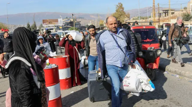 Syrian and Lebanese travelers walk at the Masnaa eastern Lebanese border crossing with Syria on December 10, 2024. I