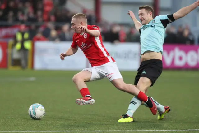 Cliftonville's Jonny Addis tackles Larne's Conor McKendry