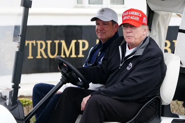 Donald Trump driving a golf cart outside Turnberry