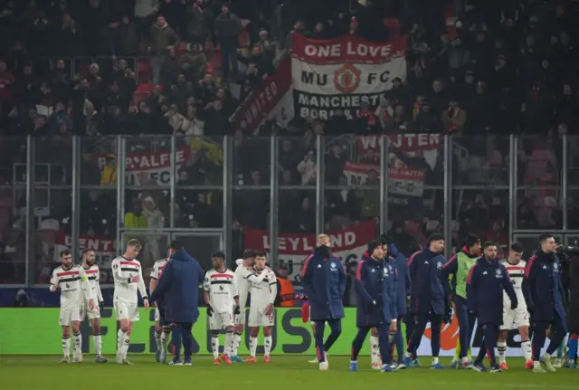 United players celebrate with the away fans at full time