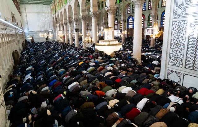 Lines of men pray at the Umayyad Mosque in Damascus, Syria