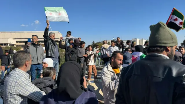 Crowds gather and raise independence flags in Umayyad Square in Damascus