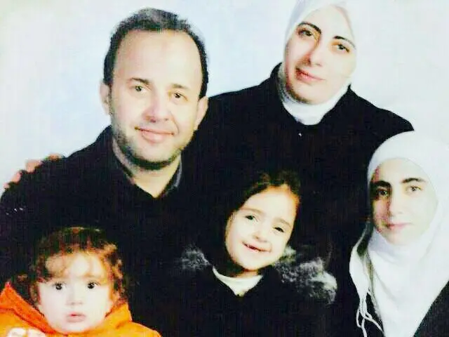 Dina - wearing a white head covering - with her husband Amaar with their three children before they were arrested