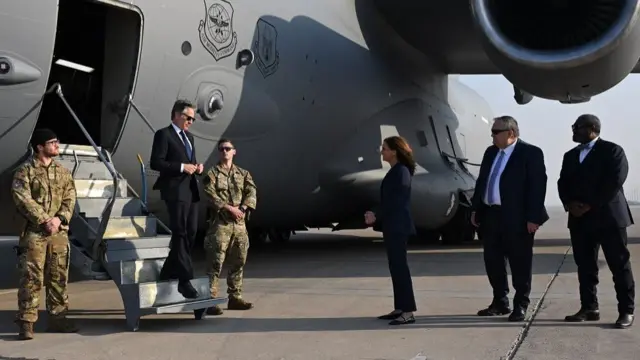 Antony Blinken steps down from a US aircraft as Iraqi officials line up to meet him