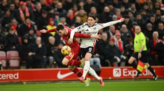 Andrew Robertson vies with Fulham midfielder Harry Wilson