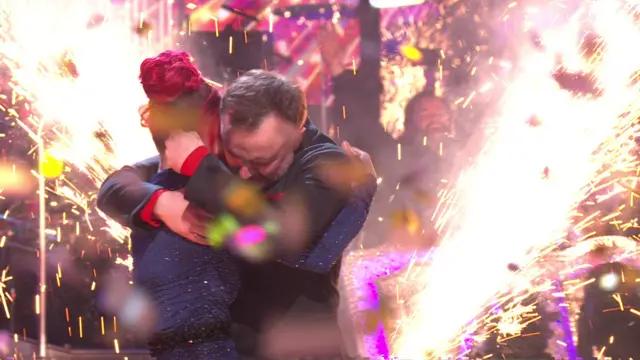 Chris and Dianne hug as dancefloor fireworks set off next to them