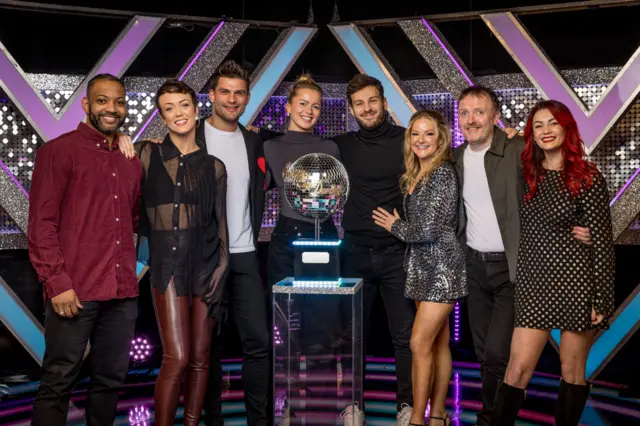 JB Gill, Tasha Ghouri, Sarah Hadland and Chris McCausland stood with their partners around the Glitterball trophies