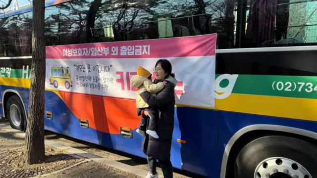 Jiwoo’s mom posing in front of her bus