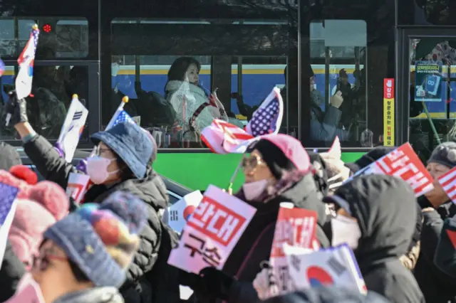 A woman ridding a bus watches people taking part in a rally supporting South Korea's President Yoon Suk Yeol at Gwanghwamun