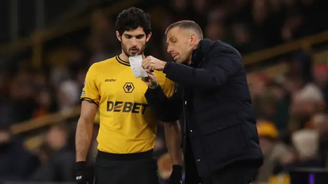 Gary O'Neil, head coach of Wolverhampton Wanderers, gives instructions to Goncalo Guedes