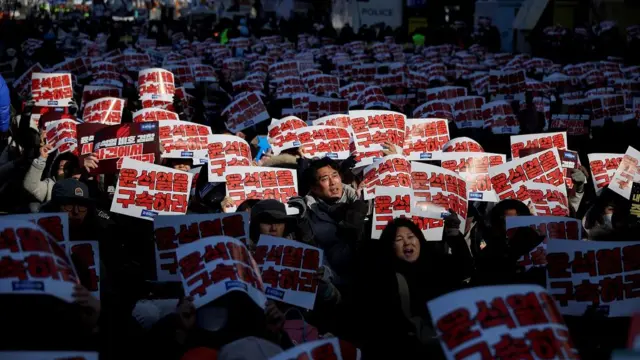 People holding banners sitting on a road