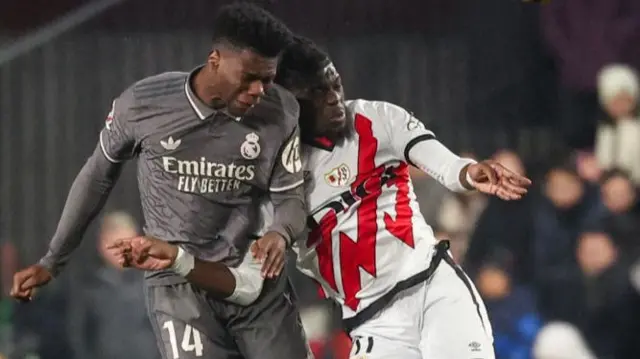 Real Madrid's French midfielder #14 Aurelien Tchouameni (L) and Rayo Vallecano's Angolan midfielder #11 Randy Nteka go for a header during the Spanish league football match between Rayo Vallecano de Madrid and Real Madrid CF at the Vallecas stadium in Madrid on December 14, 2024.