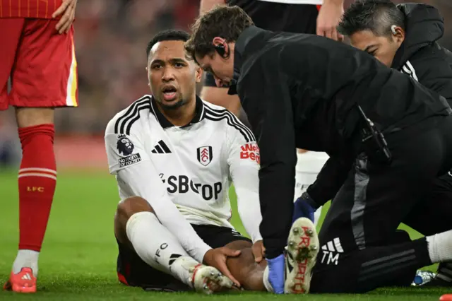 Fulham's Dutch defender #02 Kenny Tete is treated by medical staff after picking up an injury