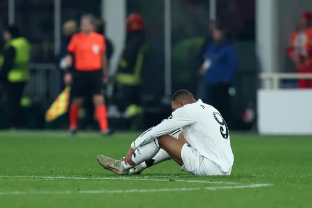 Kylian Mbappe sat on the pitch