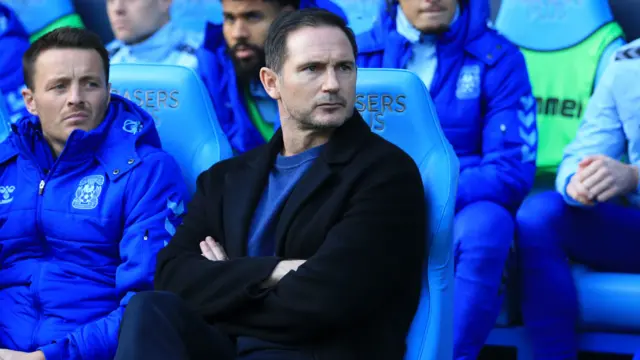 Frank Lampard watches on sitting in the dugout