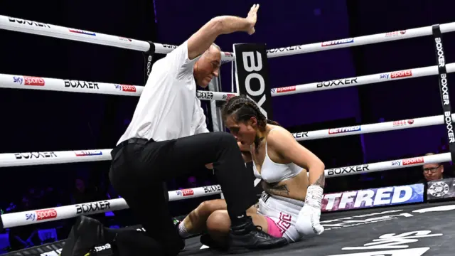 The referee waves the fight off as Bexcy Mateus struggles on the canvas