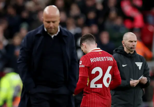 Liverpool's Andrew Robertson leaves the pitch after being shown a red card as Liverpool manager Arne Slot reacts