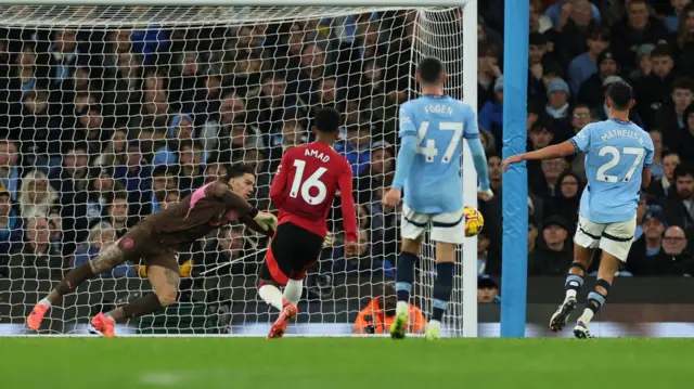 Manchester City's Ederson in action as he makes a save after Manchester United's Amad Diallo heads at goal