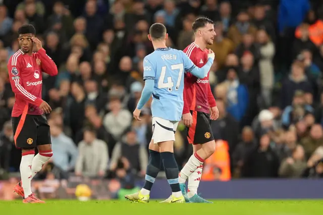 Manchester United's Mason Mount is embraced by Manchester City's Phil Foden as he leaves the pitch after going down injured