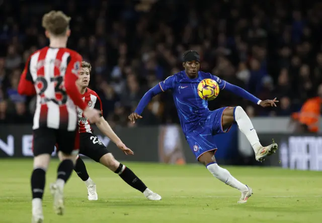 Chelsea's Noni Madueke in action with Brentford's Nathan Collins