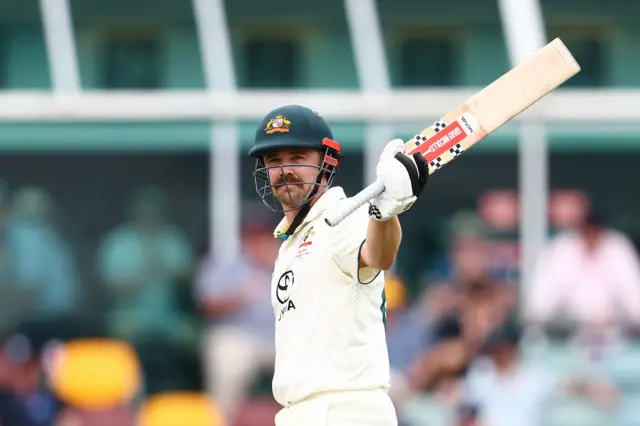 Travis Head celebrates his half-century