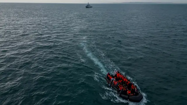 An inflatable dinghy carrying migrants makes its way towards England in the English Channel