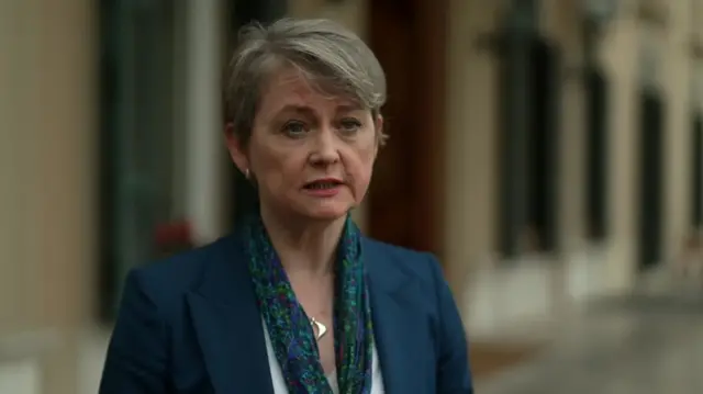 Home Secretary Yvette Cooper wearing a teal blazers and blue and green scarf with a silver necklace