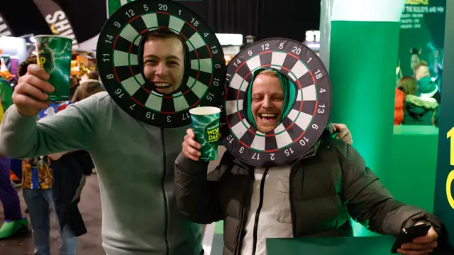 Spectators with dartboards as headgear