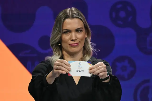 Swiss football player Lara Dickenmann shows the paper slip of Spain during the draw