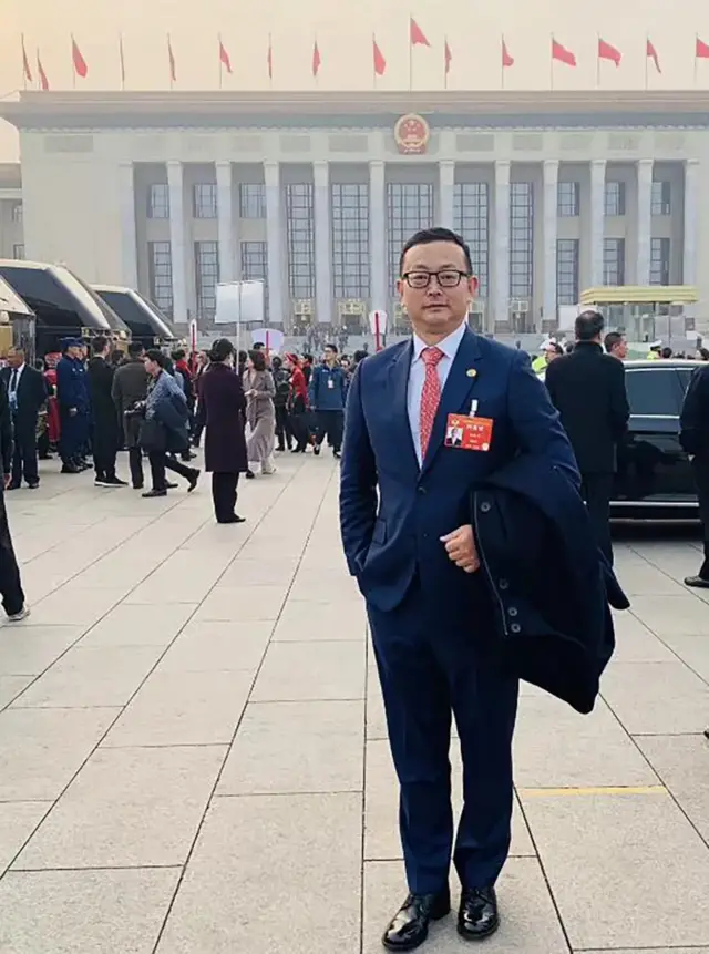 Yang Tengbo stands in front of a government building in Beijing