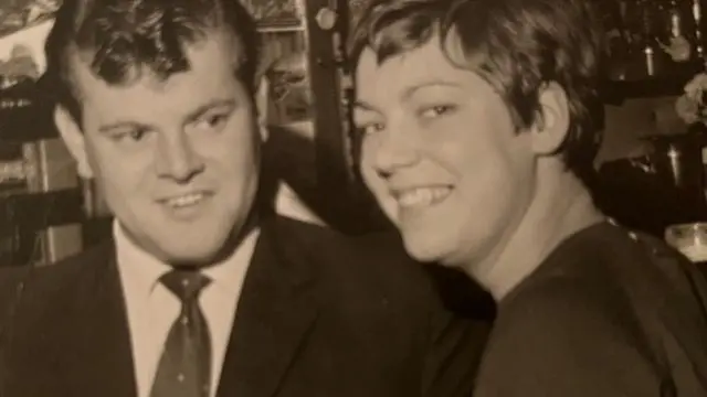 A black and white photo of Peter and Leny, Peter on the left wearing a suit and tie, Leny with a pixie cut