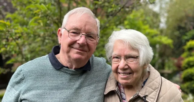 Robert and Margaret Isdale smiling at the camera with trees behind them