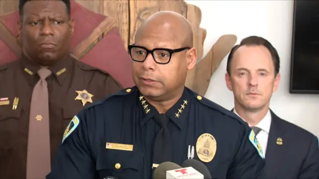Shon Barnes standing at a podium with microphones in front of him