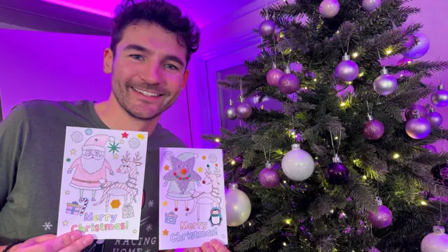 BBC Radio Somerset's Charlie Taylor with two Christmas cards he decorated