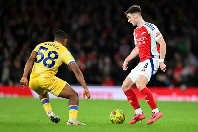 Kieran Tierney of Arsenal controls the ball whilst under pressure from Caleb Kporha