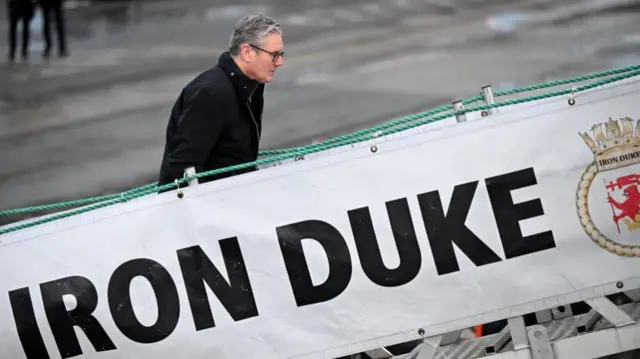 Starmer walks up a ramp with a banner reading 'Iron Duke'