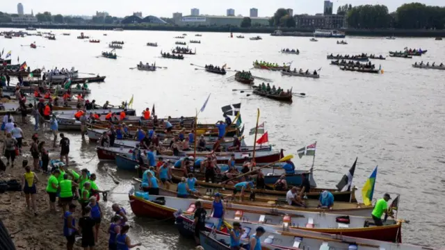 Boats line up at the shore while some are on the water