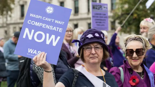 Women Against State Pension Inequality (WASPI) campaigners and their supporters demonstrate in Parliament Square on Budget Day calling for compensation for all women born in the 1950s who were affected by changes to State Pension age in London, United Kingdom on October 30, 2024. A woman is wearing a purple hat and holding a sign that reads "Waspi can't wait, compensate now"