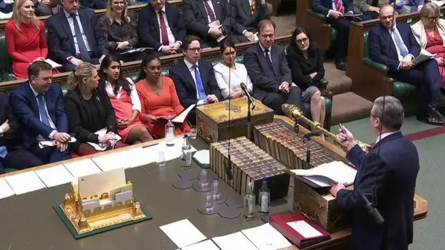 Keir Starmer with his back to the camera points at the Conservative benches in the Commons during PMQs