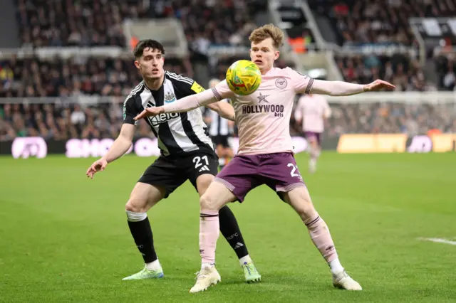 Tino Livramento of Newcastle United and Keane Lewis-Potter of Brentford battle for possession