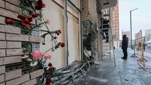 Pink and red flowers have been stuck in-between broken brickwork at the scene of the attack which killed Kirillov and his assistant