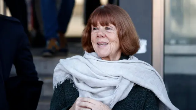 Gisèle clasping her hands and smiling as she leaves court